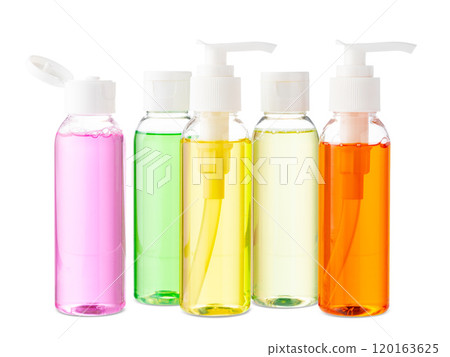 Variety of colorful personal care bottles and grooming accessories arranged on a white surface 120163625