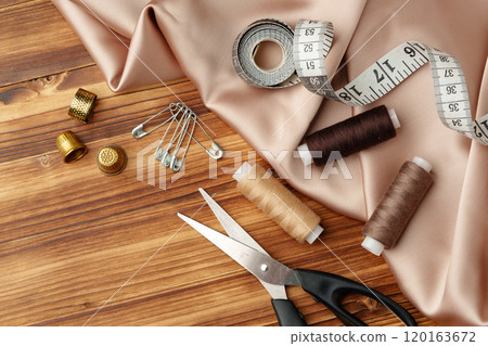 Sewing tools and materials arranged on soft fabric showcasing essential crafting supplies for creative projects 120163672
