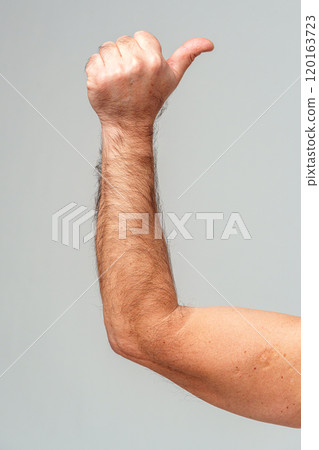 A hand giving a thumbs-up gesture against a neutral background A hand giving a thumbs-up gesture against a neutral background 120163723