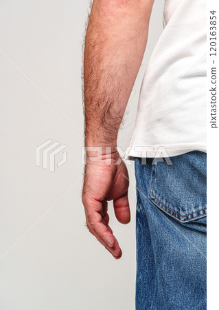 A close-up view of a man's bare hand resting against his side A close-up view of a man's bare hand resting against his side 120163854