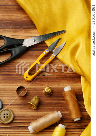 Crafting tools and materials arranged on a wooden table ready for sewing and creative projects 120163861