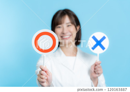 A woman wearing a white lab coat and holding a round X plate A woman wearing a white lab coat and holding a round X plate 120163887