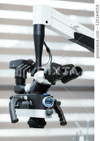 A detailed view of a dental microscope prepared for a procedure in a dental clinic 120164058