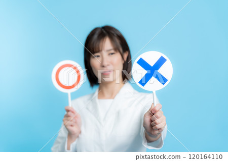 A woman wearing a white lab coat and holding a round X plate 120164110