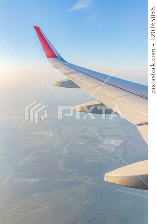 View from the airplane window at a beautiful cloudy sky and the airplane wing View from the airplane window at a beautiful cloudy sky and the airplane wing 120165036
