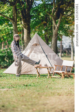 A young woman having fun in front of a tent A young woman having fun in front of a tent 120165061