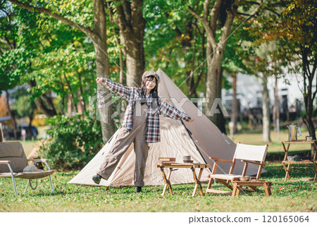 A young woman having fun in front of a tent A young woman having fun in front of a tent 120165064