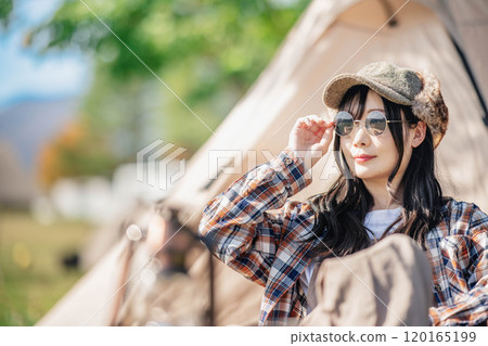 坐在帳篷前戴著墨鏡的年輕女子 坐在帳篷前戴著墨鏡的年輕女子 120165199