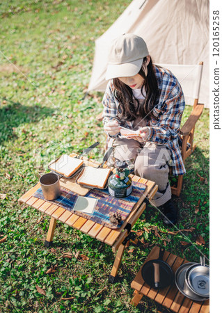 Young woman preparing lunch for camping 120165258