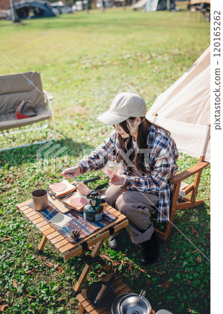 Young woman preparing lunch for camping Young woman preparing lunch for camping 120165262