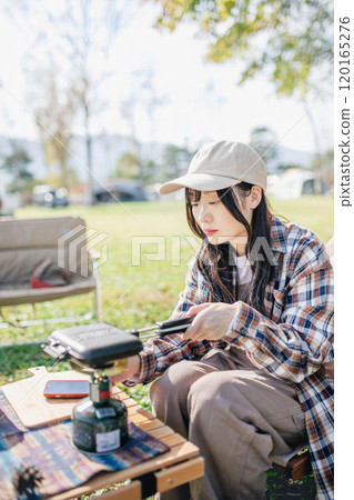 Young woman preparing lunch for camping 120165276