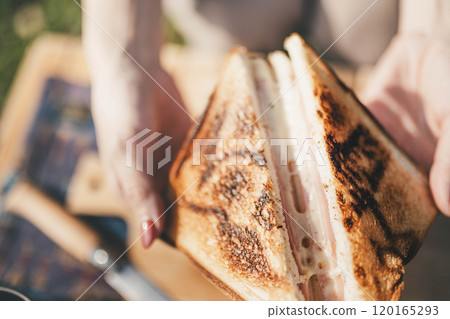 Woman eating at camp 120165293