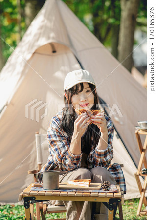 一名婦女在露營地吃飯 一名婦女在露營地吃飯 120165376