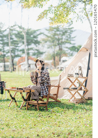 Woman eating snacks at a campsite 120165470