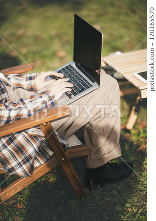 Young woman working at a campsite Young woman working at a campsite 120165570