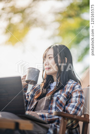 Young woman working at a campsite Young woman working at a campsite 120165575