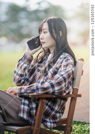Young woman working at a campsite Young woman working at a campsite 120165592