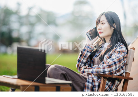 Young woman working at a campsite 120165593
