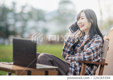 Young woman working at a campsite 120165594