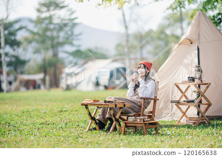 Woman eating snacks at a campsite 120165638