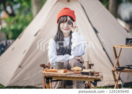 Woman eating snacks at a campsite 120165640