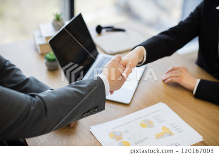 Business professionals shaking hands after successful meeting conclusion 120167003