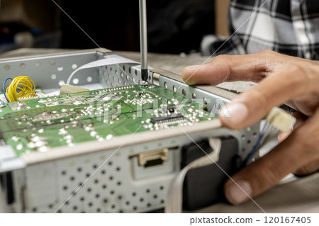 Man technician repairing television with a screwdriver Man technician repairing television with a screwdriver 120167405