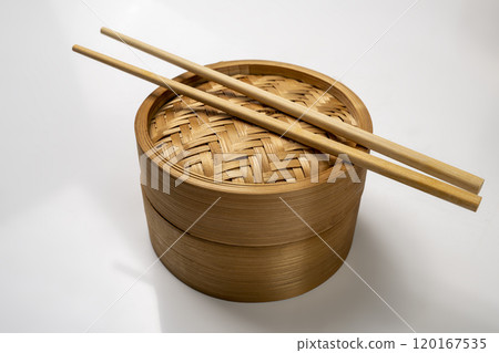 Chinese dim sum dumpling bamboo bowl basket with chopsticks isolated over white background 120167535