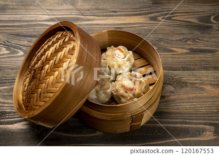 Chinese dim sum dumpling on bamboo wooden basket bowl on wooden table 120167553