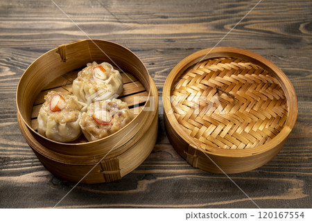 Chinese dim sum dumpling on bamboo wooden basket bowl on wooden table 120167554