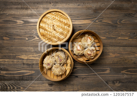 Assorted chinese dim sum dumpling on bamboo wooden basket bowl on wooden table 120167557