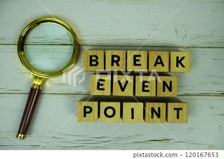 Break Even Point with wooden blocks alphabet letters and magnifying glass on wooden background Break Even Point with wooden blocks alphabet letters and magnifying glass on wooden background 120167653