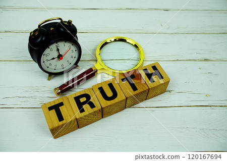 Truth alphabet letters with magnifying glass and alarm clcok top view of wooden background 120167694