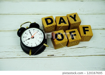 Day Off alphabet letters with alarm clock top view on wooden background Day Off alphabet letters with alarm clock top view on wooden background 120167695