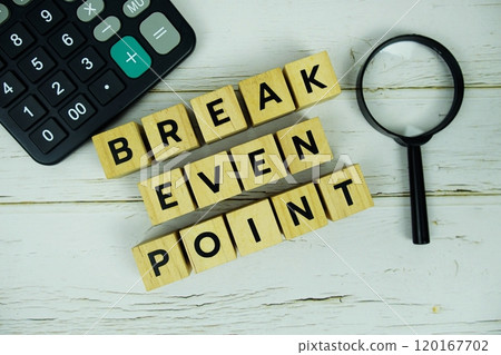 Break Even Point with wooden blocks alphabet letters and magnifying glass, calculator top view on wooden background Break Even Point with wooden blocks alphabet letters and magnifying glass, calculator top view on wooden background 120167702