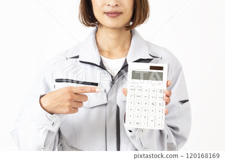 A woman in work clothes holding a calculator A woman in work clothes holding a calculator 120168169