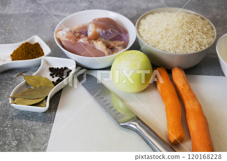 A cutting board with bowls of chicken, carrots, onions, rice 120168228