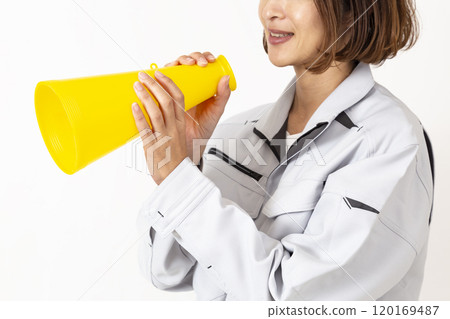A woman in work clothes holding a megaphone 120169487