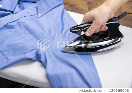 一個男人的手熨燙襯衫的特寫 120169628