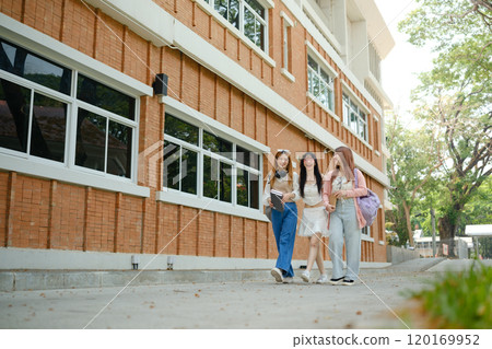 Three young women walking down a brick sidewalk Three young women walking down a brick sidewalk 120169952