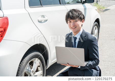 身穿西裝的年輕亞洲男子，擔任推銷員/二手車評估師，評估二手車。 120170275