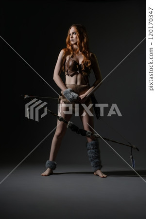 A poised warrior stands confidently in a creative studio during a dramatic shoot A poised warrior stands confidently in a creative studio during a dramatic shoot 120170347