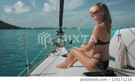 Girl relaxing on a yacht in ocean. Slim Caucasian brunette woman sitting on boat nose, tanning, relax, enjoying an active lifestyle summer holiday travel tourism vacation adventure. Slow 120171216