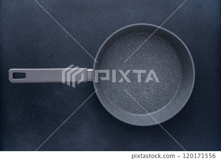 New granite frying pan on a gray background, top view. Empty fry pan with handle. 120171556