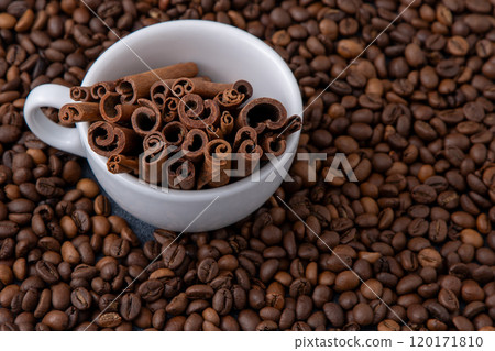 Coffee beans and cinnamon sticks in a cup. Food drink background. Coffee beans and cinnamon sticks in a cup. Food drink background. 120171810