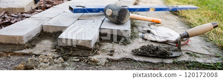 Laying paving stones on cement mortar. banner. Laying a garden path made of tiles. Self-laying of concrete paving slabs in the courtyard of the house. do it yourself. DIY 120172008