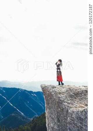 A woman standing on the fire rocks of Iwashi Plateau 120172187