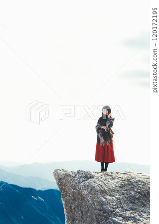 A woman standing on the fire rocks of Iwashi Plateau 120172195