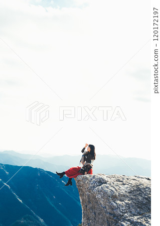 A woman sitting on the fire rocks of Oishi Plateau 120172197