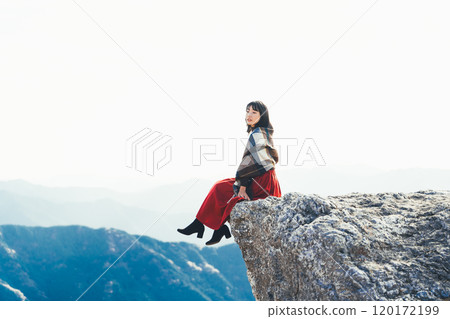 A woman sitting on the fire rocks of Oishi Plateau A woman sitting on the fire rocks of Oishi Plateau 120172199